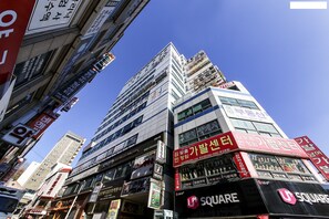 Un edificio de varios pisos con diversos rótulos comerciales y anuncios.