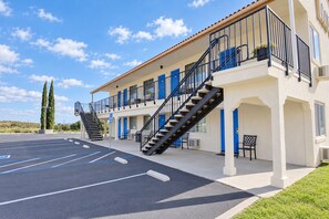 Un hôtel doté d’un parking, de plusieurs balcons et d’un escalier menant aux étages supérieurs.
