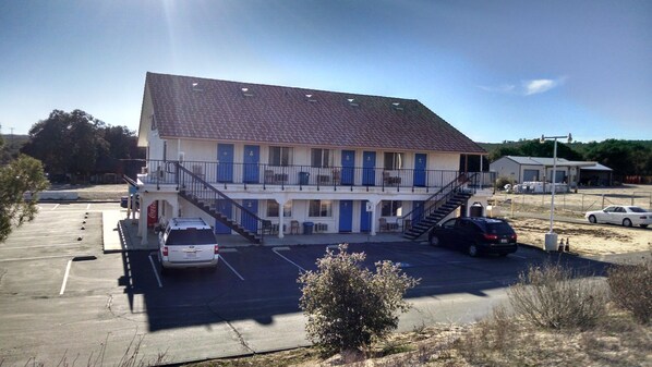 A motel with a two-story structure, a parking lot, and a small garden area.