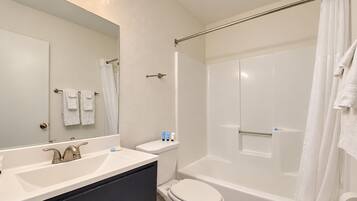 A modern bathroom with a vanity, toilet, and shower area.