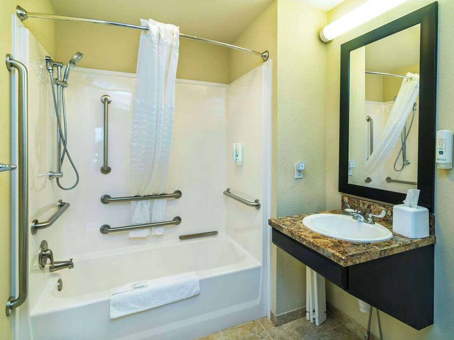 Een badkamer met een bad, een wastafel en een spiegel.