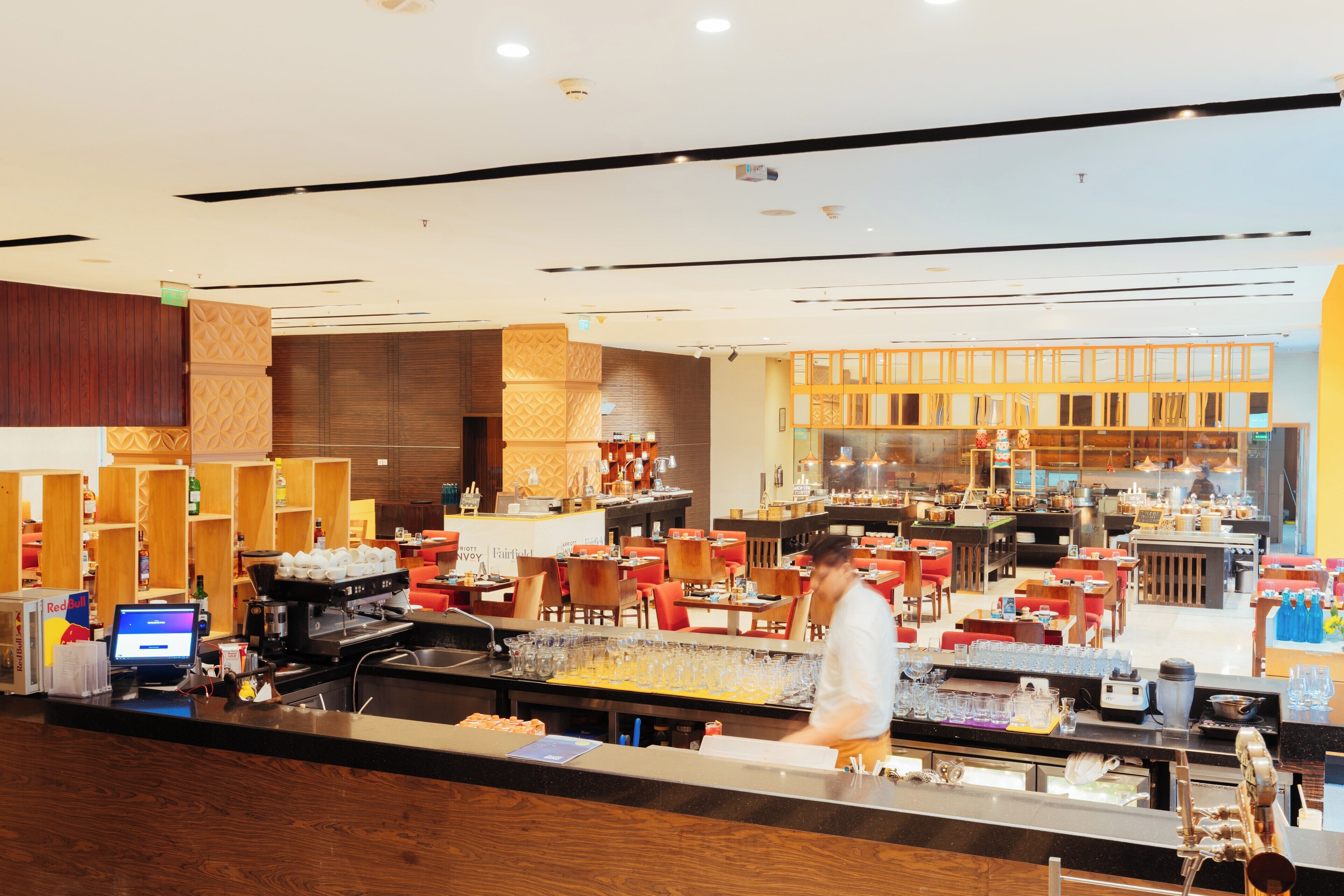 Un lobby moderno de hotel con área de bar, asientos y una recepción.