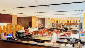 En modern hotellobby med en bardisk, sittplatser och en receptionsdisk.