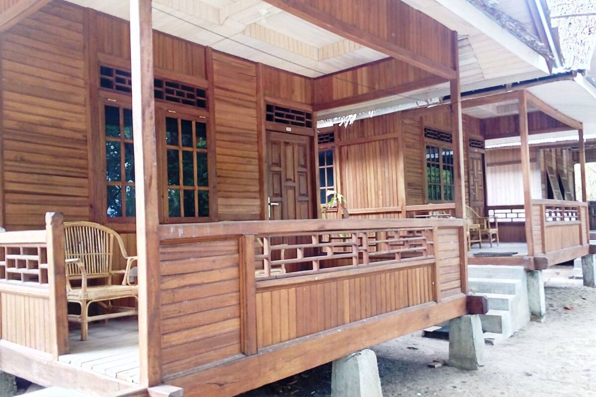 Una estructura de madera con un porche, una silla y una puerta.