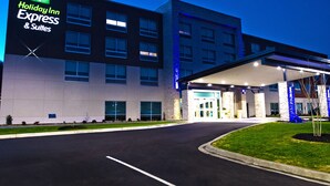 A Holiday Inn Express & Suites building with a modern design, large windows, and a well-lit entrance. - Holiday Inn Express & Suites Greenwood Mall by IHG (Greenwood)