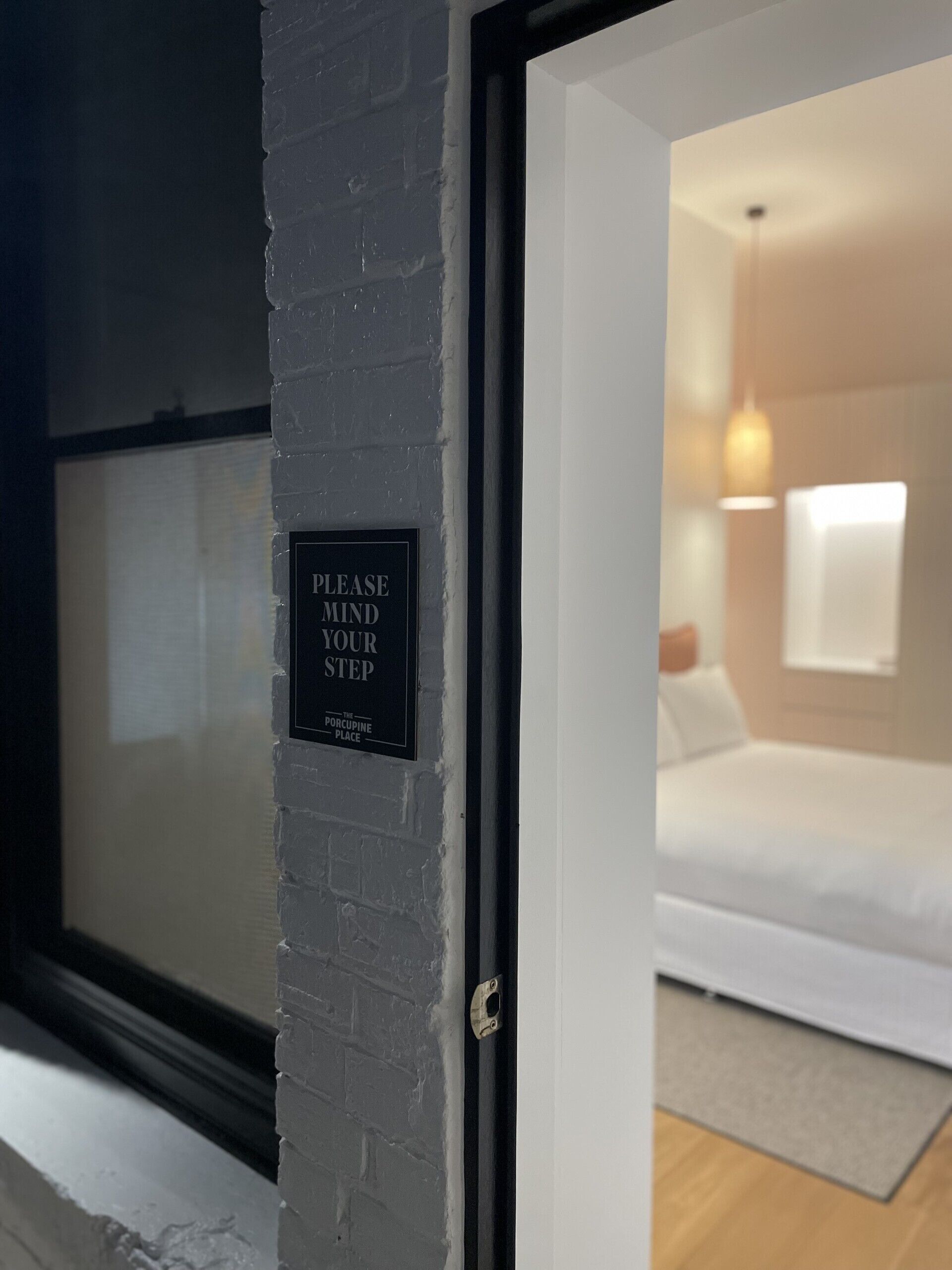 Una puerta con un letrero que dice 'POR FAVOR, TENGA CUIDADO' y 'THE PORCUPINE PLACE'.