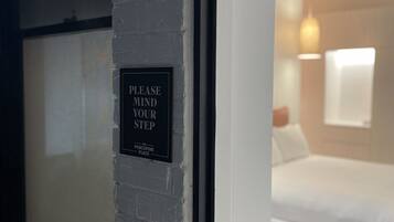 Una puerta con un letrero que dice 'POR FAVOR, TENGA CUIDADO' y 'THE PORCUPINE PLACE'.
