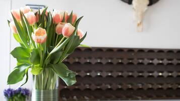 A reception desk with a vase of pink tulips, a bull's head decoration, and a small sign.