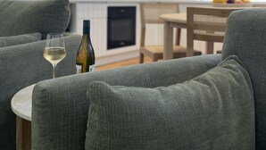 A modern living room with grey sofas, a wine glass, and a bottle on a table. - The Matador (Sale)