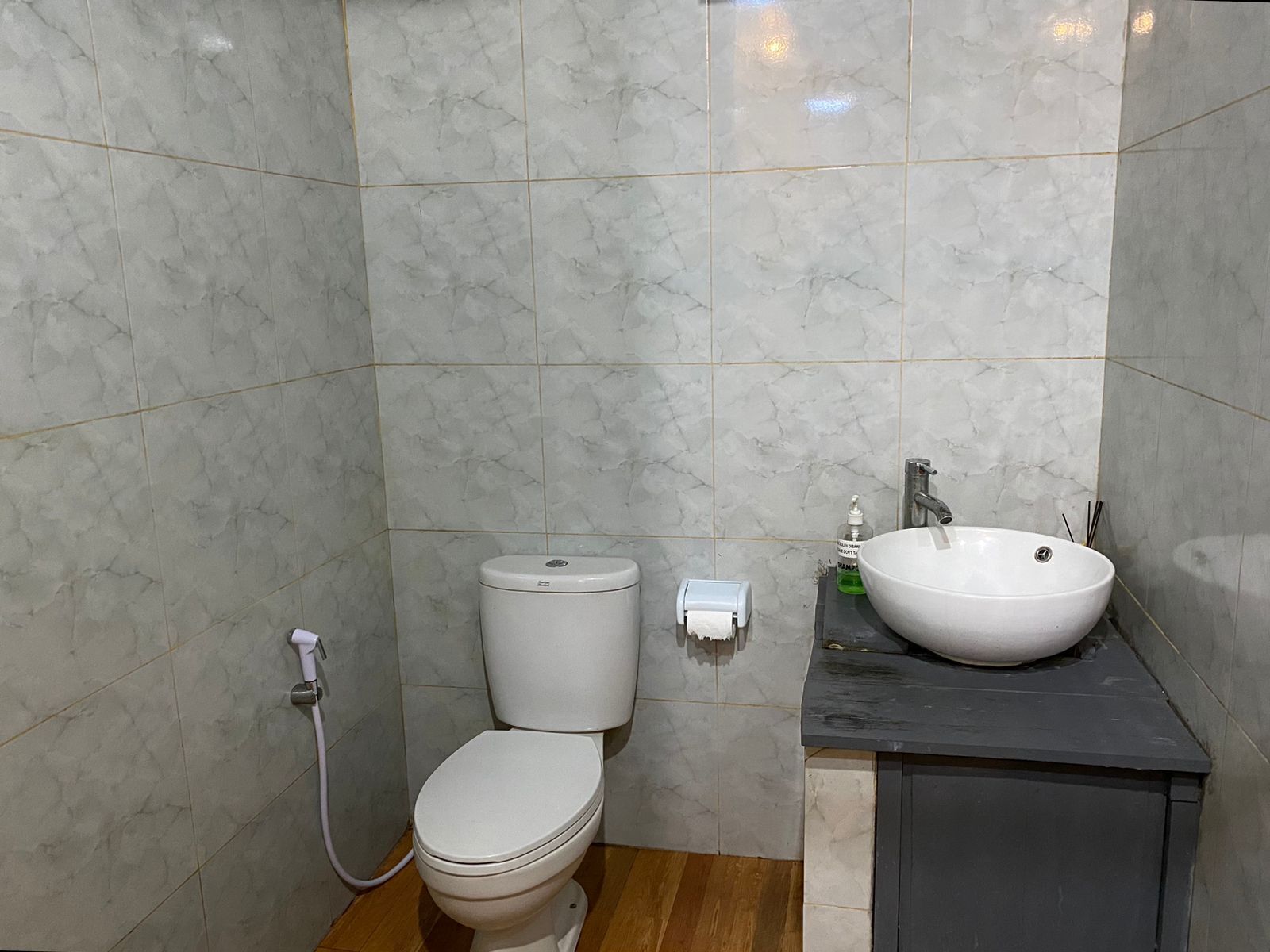 Un baño con inodoro, lavamanos y secamanos.