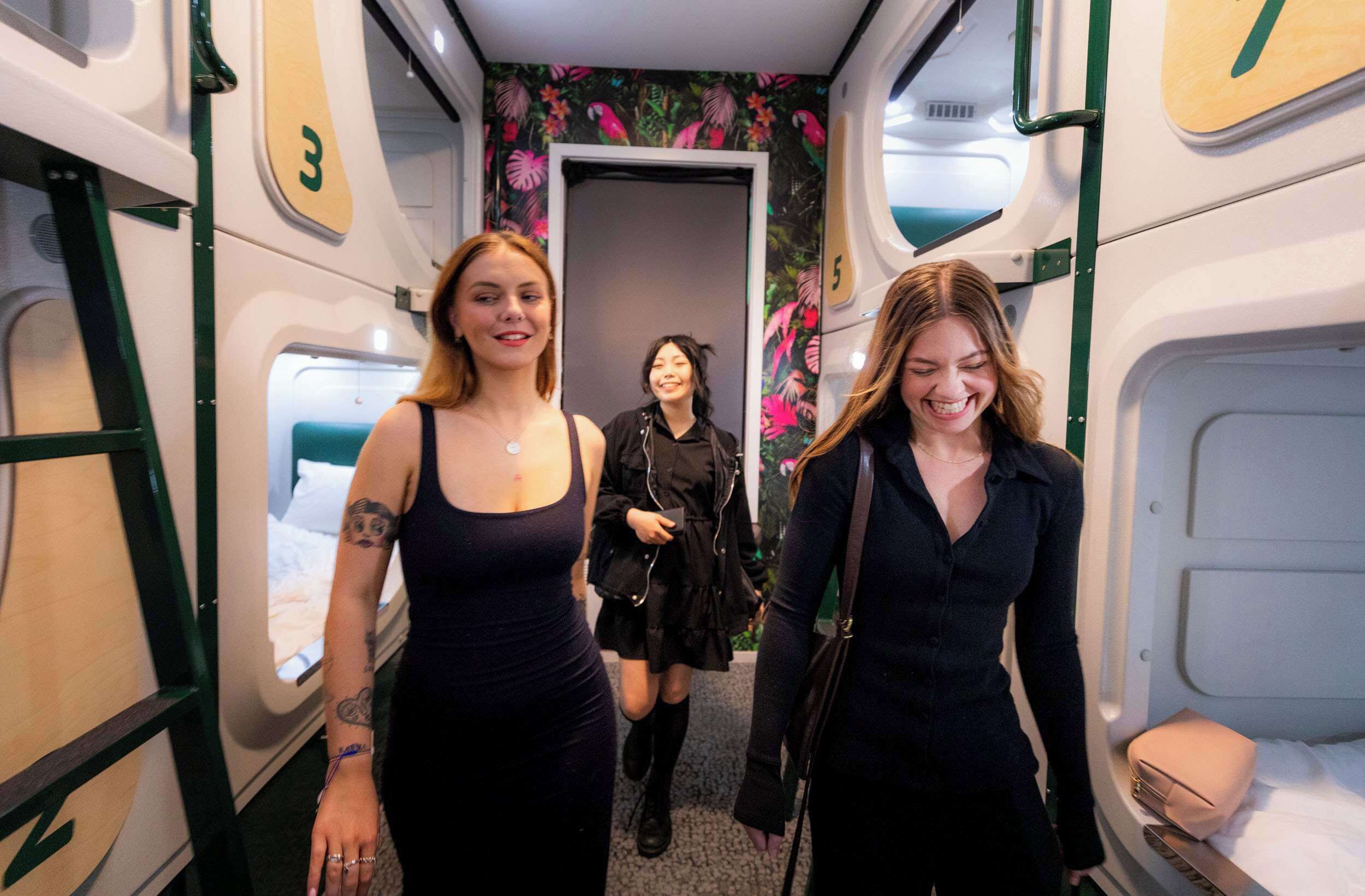 A narrow corridor with bunk beds on either side and a door at the end.