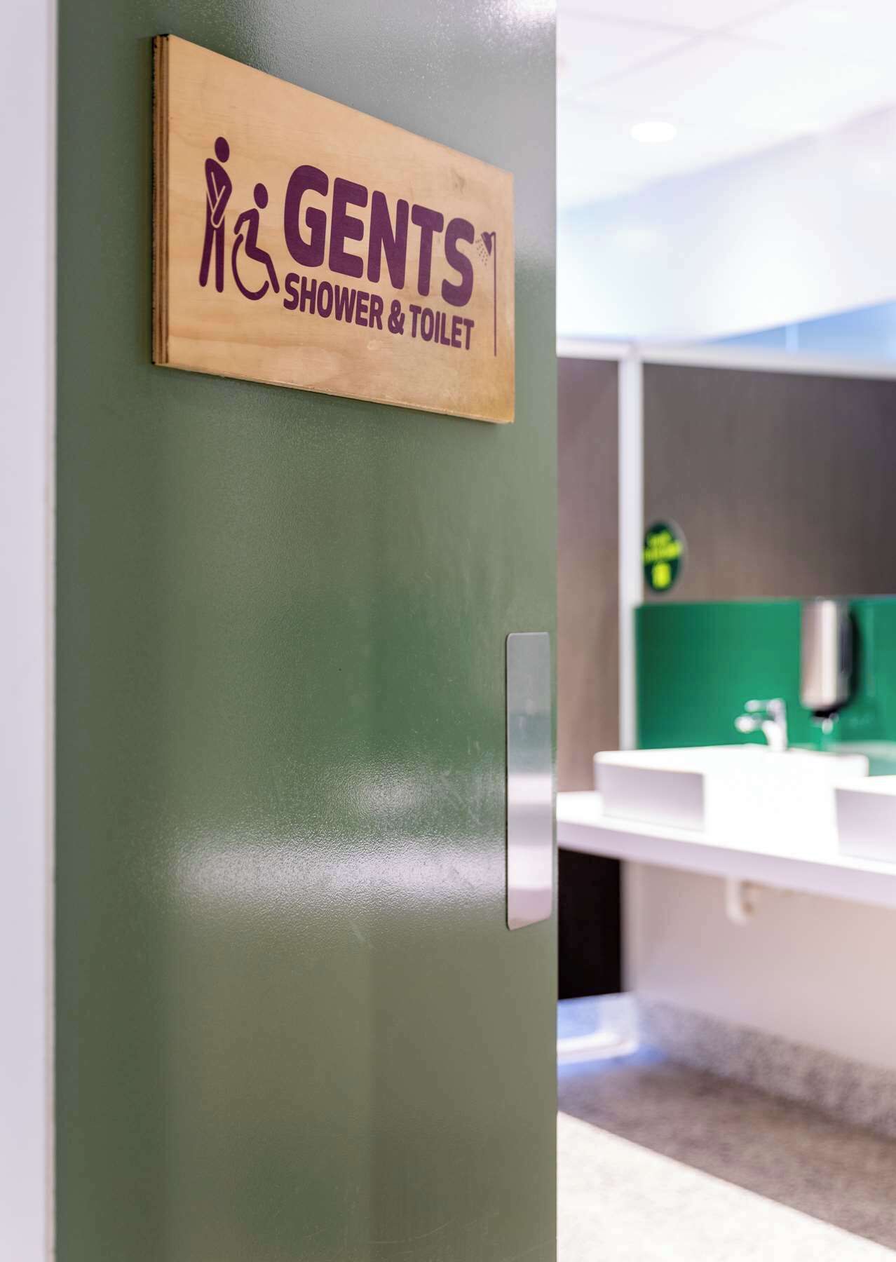 A door with a sign for 'Gents Shower & Toilet'.