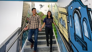 Un escalier orné d’une fresque représentant des bâtiments et un oiseau.