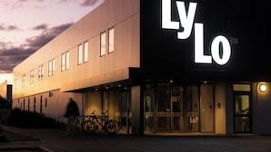 Un bâtiment moderne, reconnaissable à son grand panneau « LyLo », à ses larges fenêtres et à son espace de stationnement pour vélos.