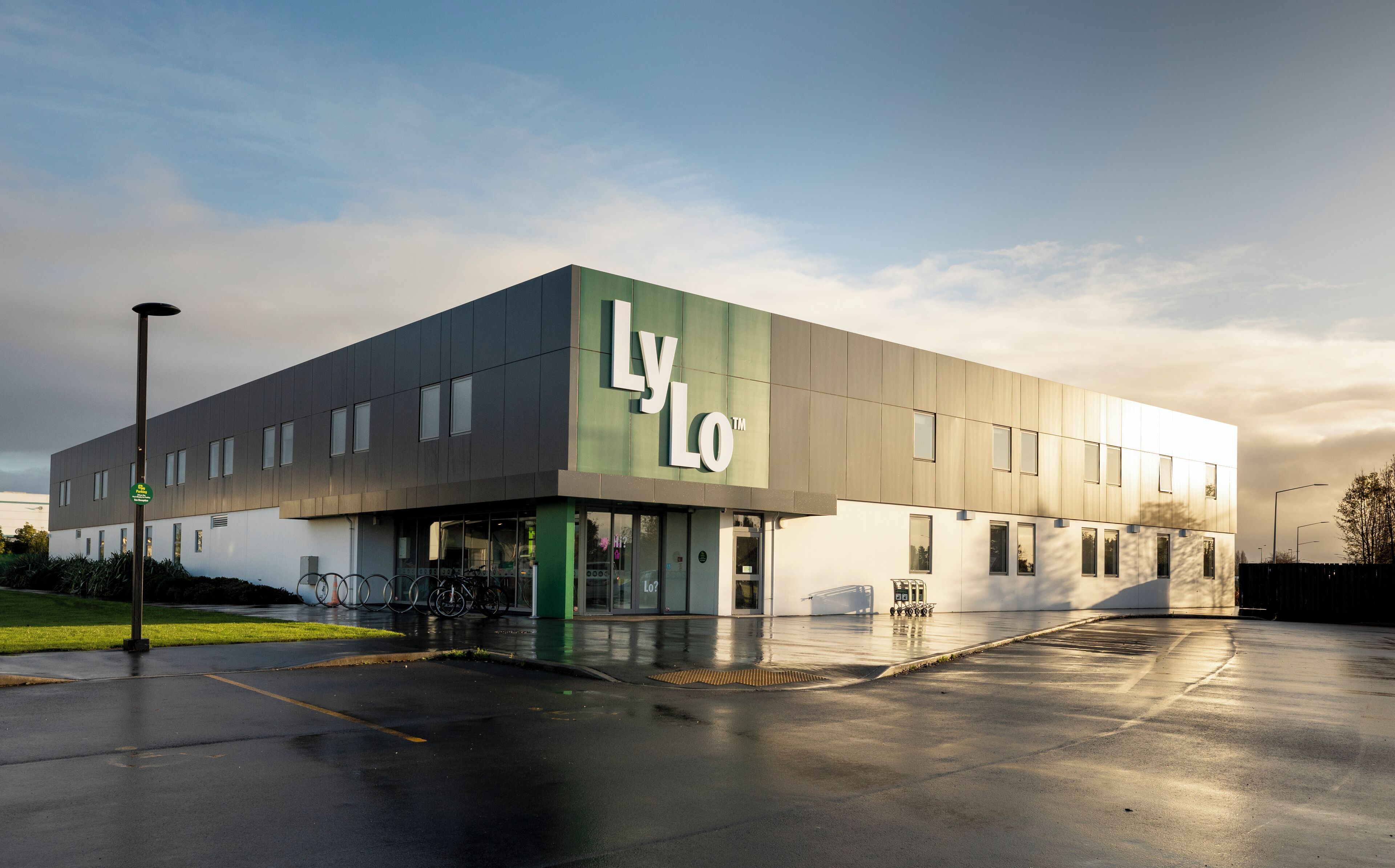 A modern building with a prominent 'Lylo' sign, featuring a flat roof and a mix of glass and metal panels.
