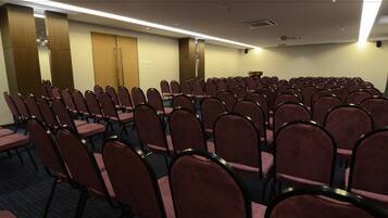 A conference room with rows of chairs and a podium.