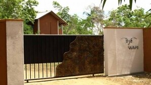 A gated entrance with a metal gate and a wall with graffiti. - Wapi Bungalowi Yala (Thissamaharama)