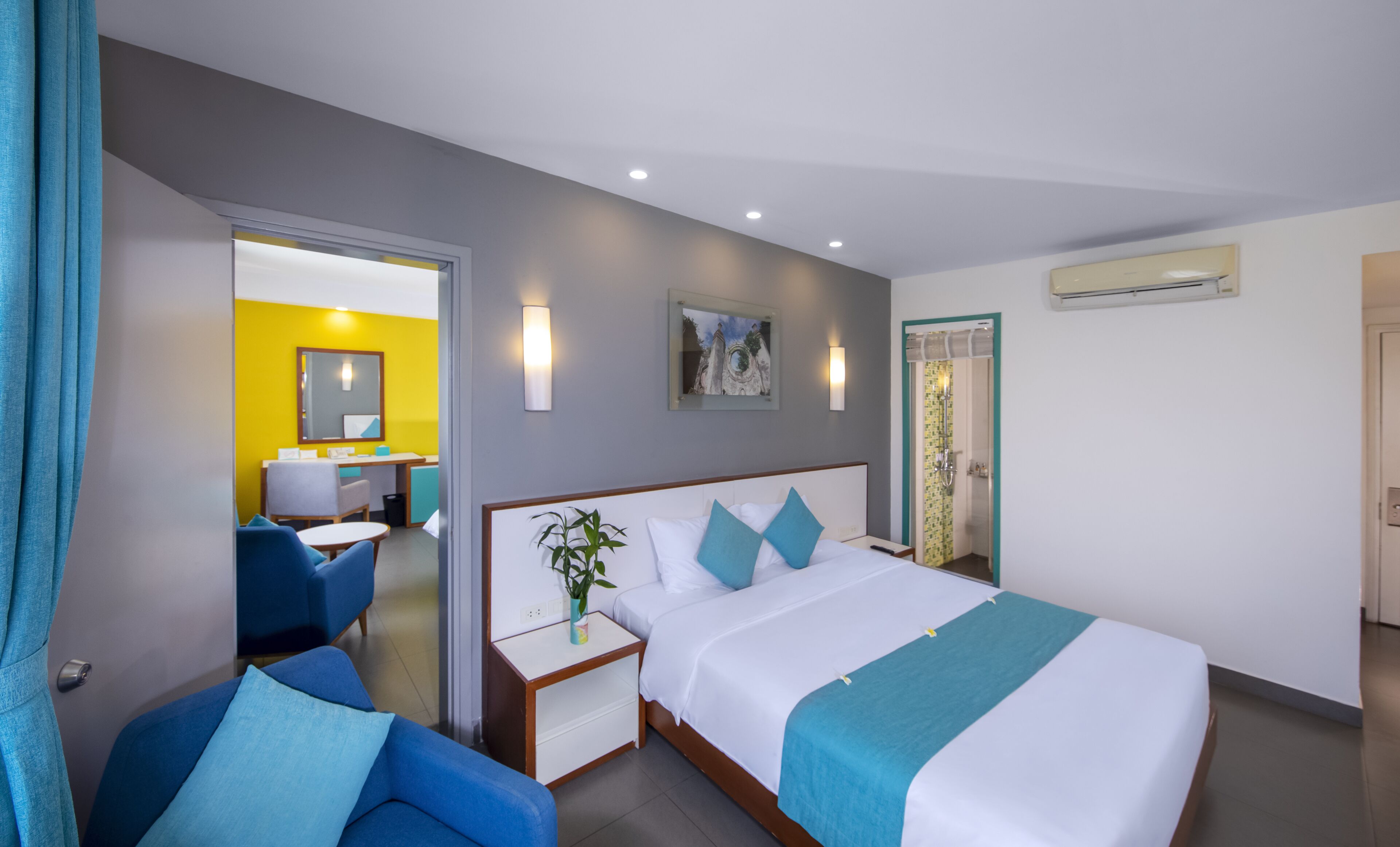 Una camera d'albergo con un letto, una scrivania, una sedia e l'accesso al bagno.