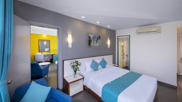 Una camera d'albergo con un letto, una scrivania, una sedia e l'accesso al bagno.