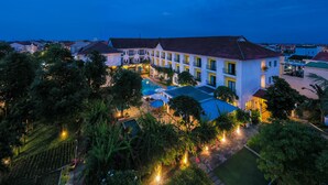A large hotel with multiple balconies and a swimming pool. - ÊMM Hotel Hoi An (Da Nang)