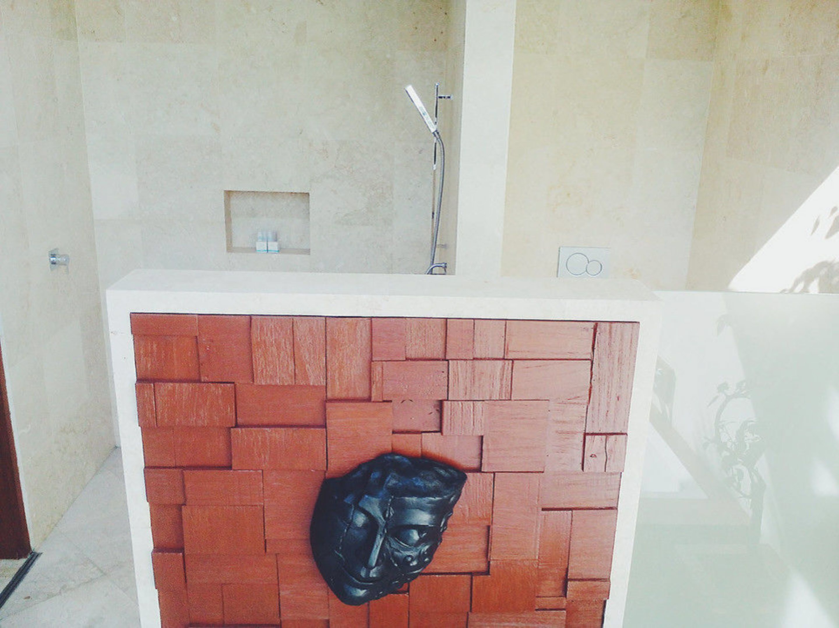 Un bagno con parete rivestita di piastrelle, zona doccia e rubinetto a parete.
