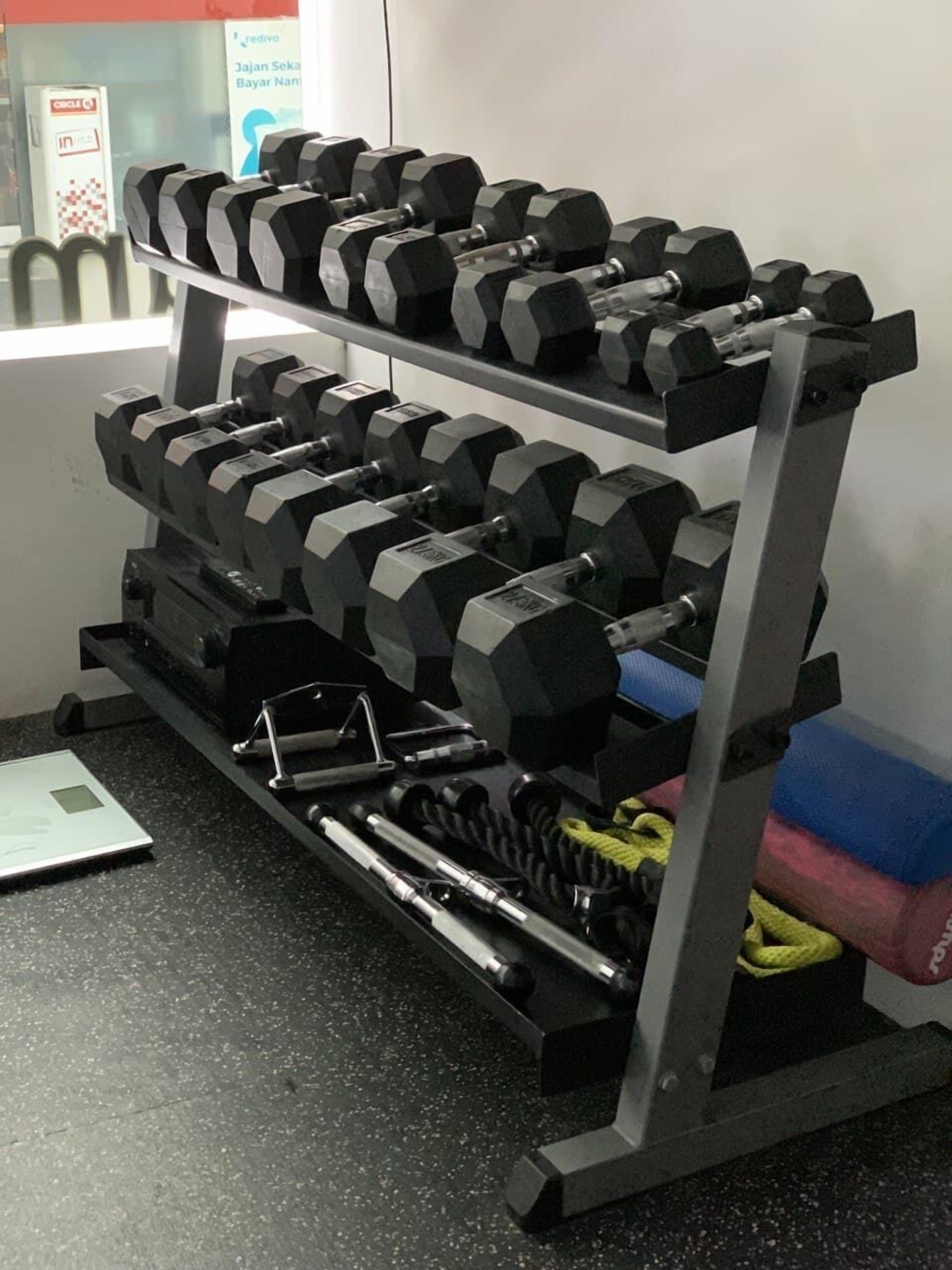 A weightlifting rack with multiple dumbbells and a scale.