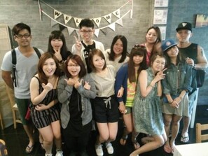 A group of people posing in a room with a 'WELCOME' banner. - Eat - Ting Cafe and Hostel (Bangkok)