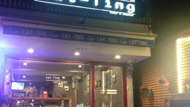 A restaurant named 'eat-Ting' with a neon sign, outdoor seating, and a glass door entrance. - Eat - Ting Cafe and Hostel (Bangkok)
