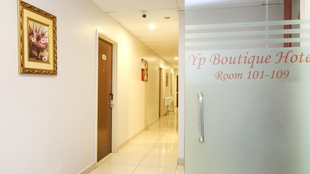 A hotel corridor with a framed floral artwork on the wall, a door labeled "103", and a sign indicating "Yp Boutique Hotel Room 101-109". - Super OYO 156 YP Boutique Hotel (Petaling Jaya)