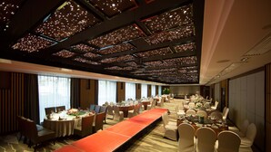 A conference room with a long table, multiple chairs, and a carpeted floor.