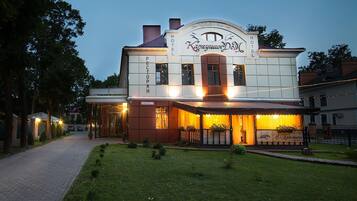 Hotel Kapryushin Dom features a classic entrance with a covered porch and decorative arch.