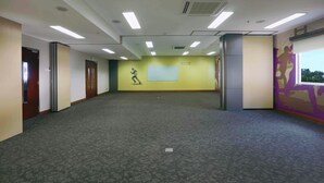 A spacious room with a carpeted floor, a whiteboard on the wall, and a window with a view. - Cordela Kartika Dewi Jogjakarta (Yogyakarta)