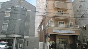 Un poste de police au design moderne, doté d’une tour cylindrique et d’un bâtiment à deux étages avec un balcon.