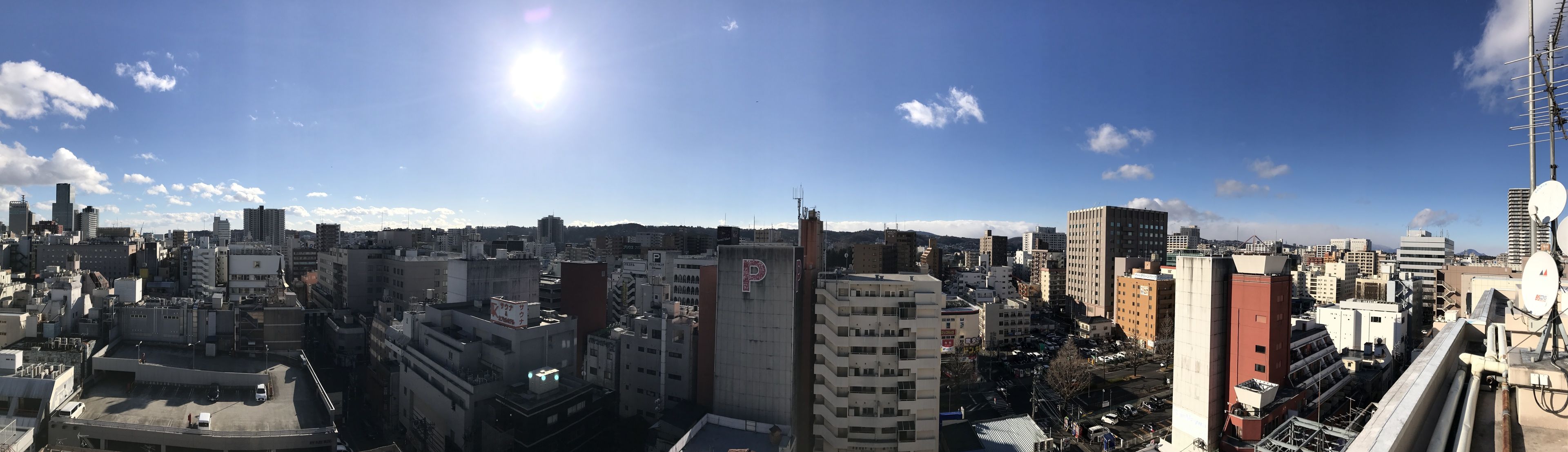 A cityscape with a variety of building heights and architectural styles, including a prominent 'P' sign on a building.