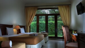 A hotel room with two beds, a desk, a chair, and a TV. - d'Emmerick Salib Putih Hotel Salatiga (Salatiga)
