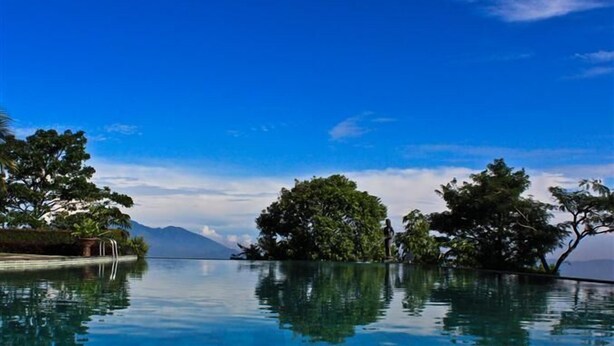 A clear blue sky, an infinity pool, and lush greenery. - d'Emmerick Salib Putih Hotel Salatiga (Salatiga)