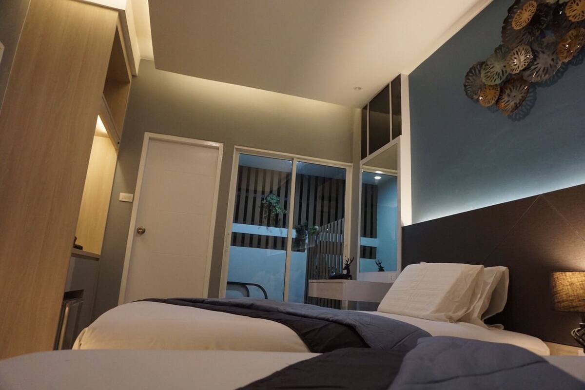 Um quarto moderno com uma cama, uma escrivaninha e um espelho grande.