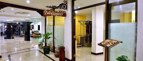 A hotel lobby with a sign for 'Neylan' and a reception desk.