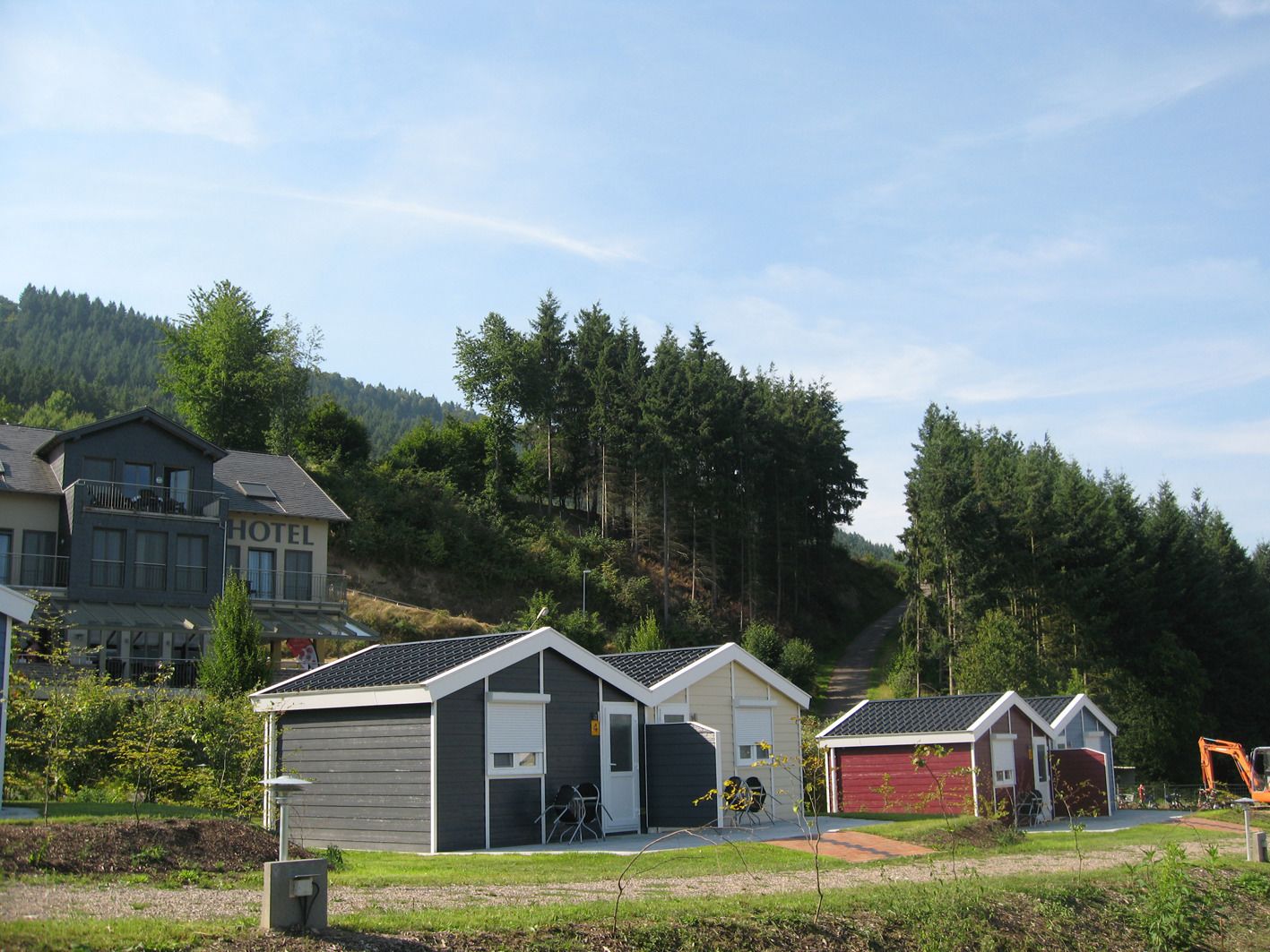 A hotel with a modern design, featuring a two-story structure with a flat roof and a covered outdoor seating area.