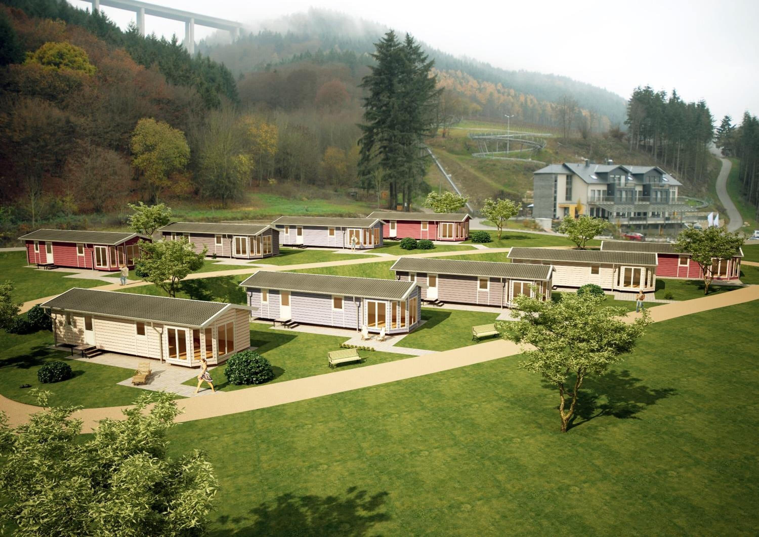 A campground with multiple mobile homes arranged in rows, a large building in the background, and a forested hillside.