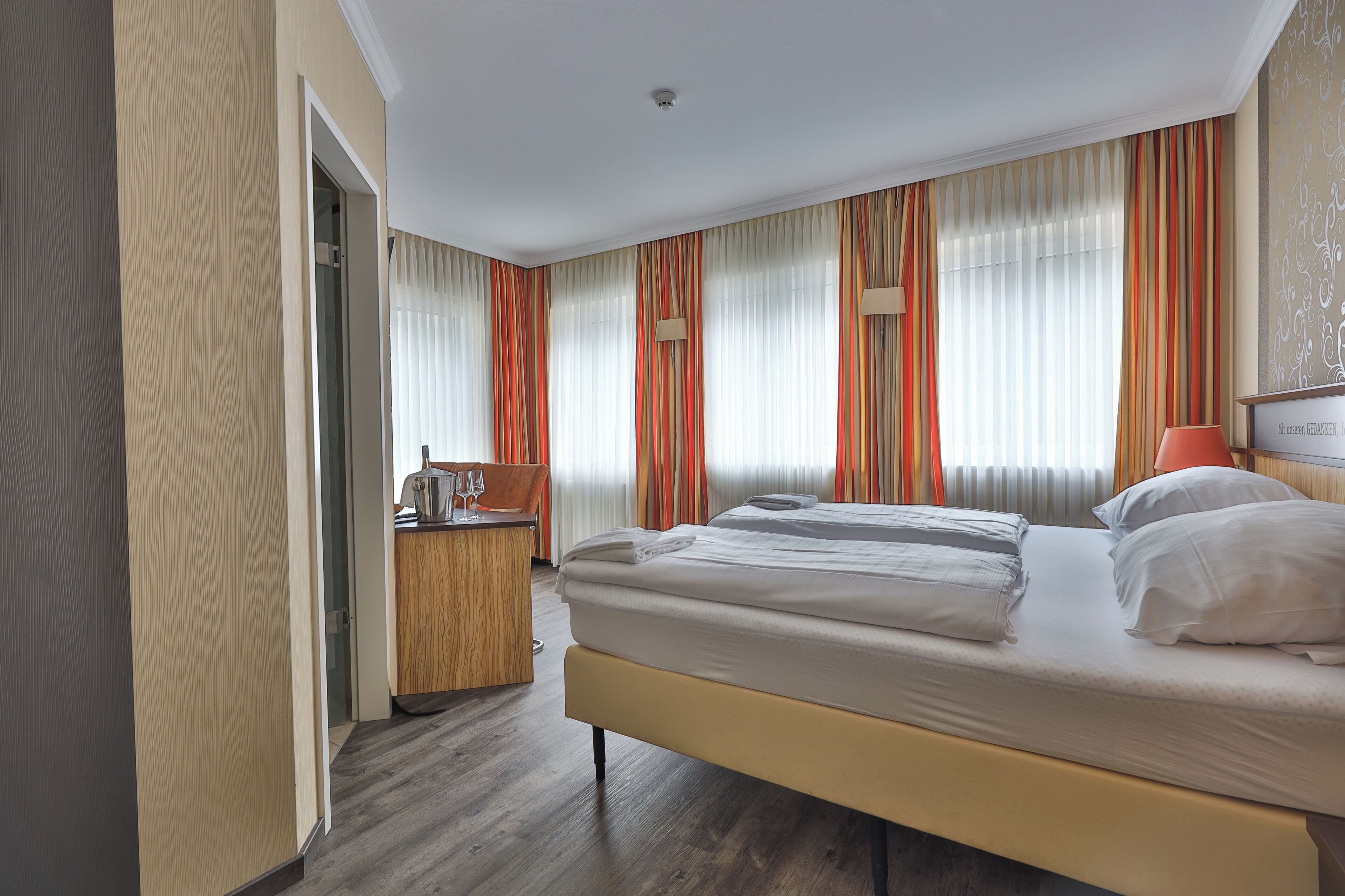 Una habitación de hotel con una cama, un escritorio y una silla.