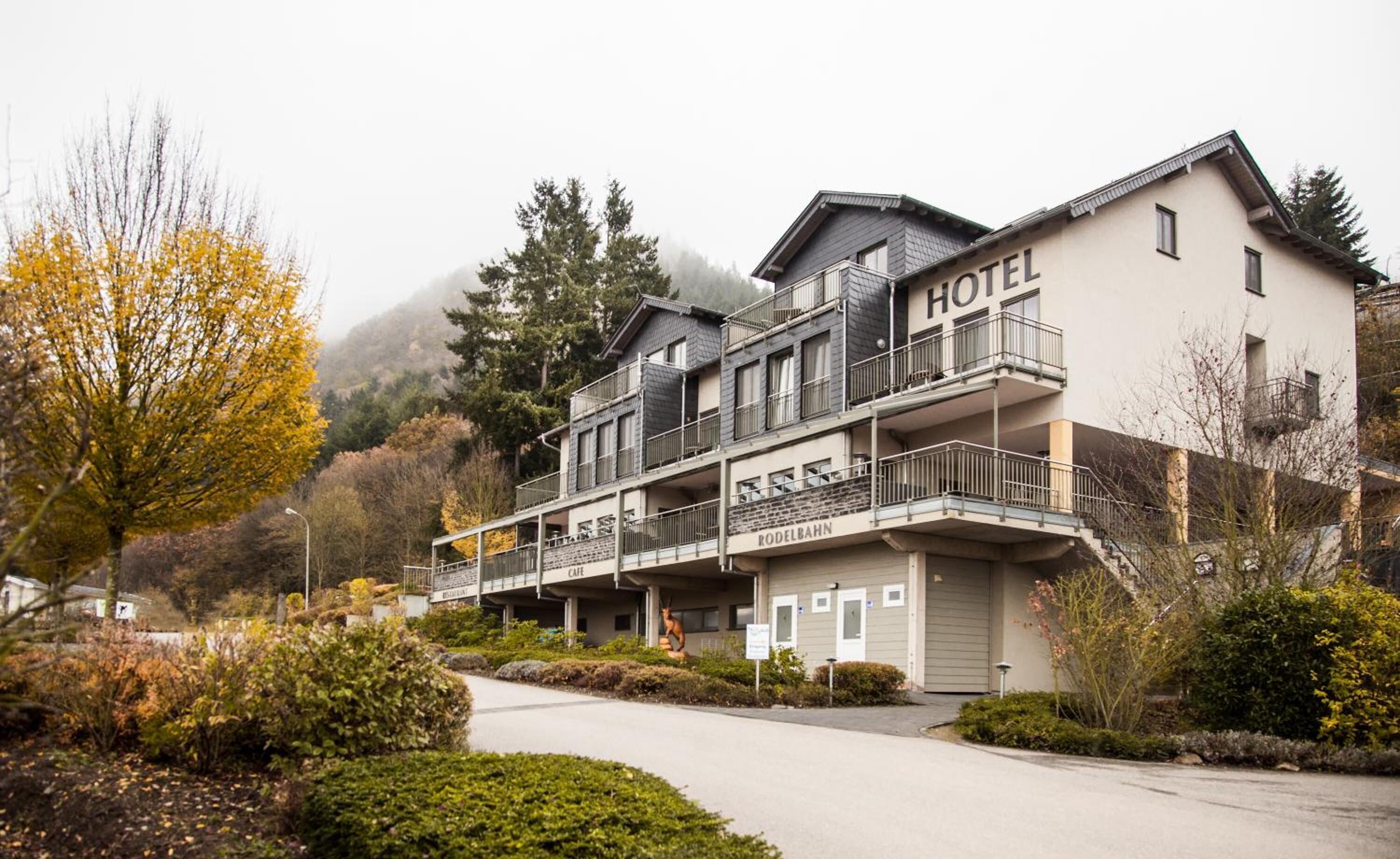 A hotel with a two-story structure, balconies, and a parking area.