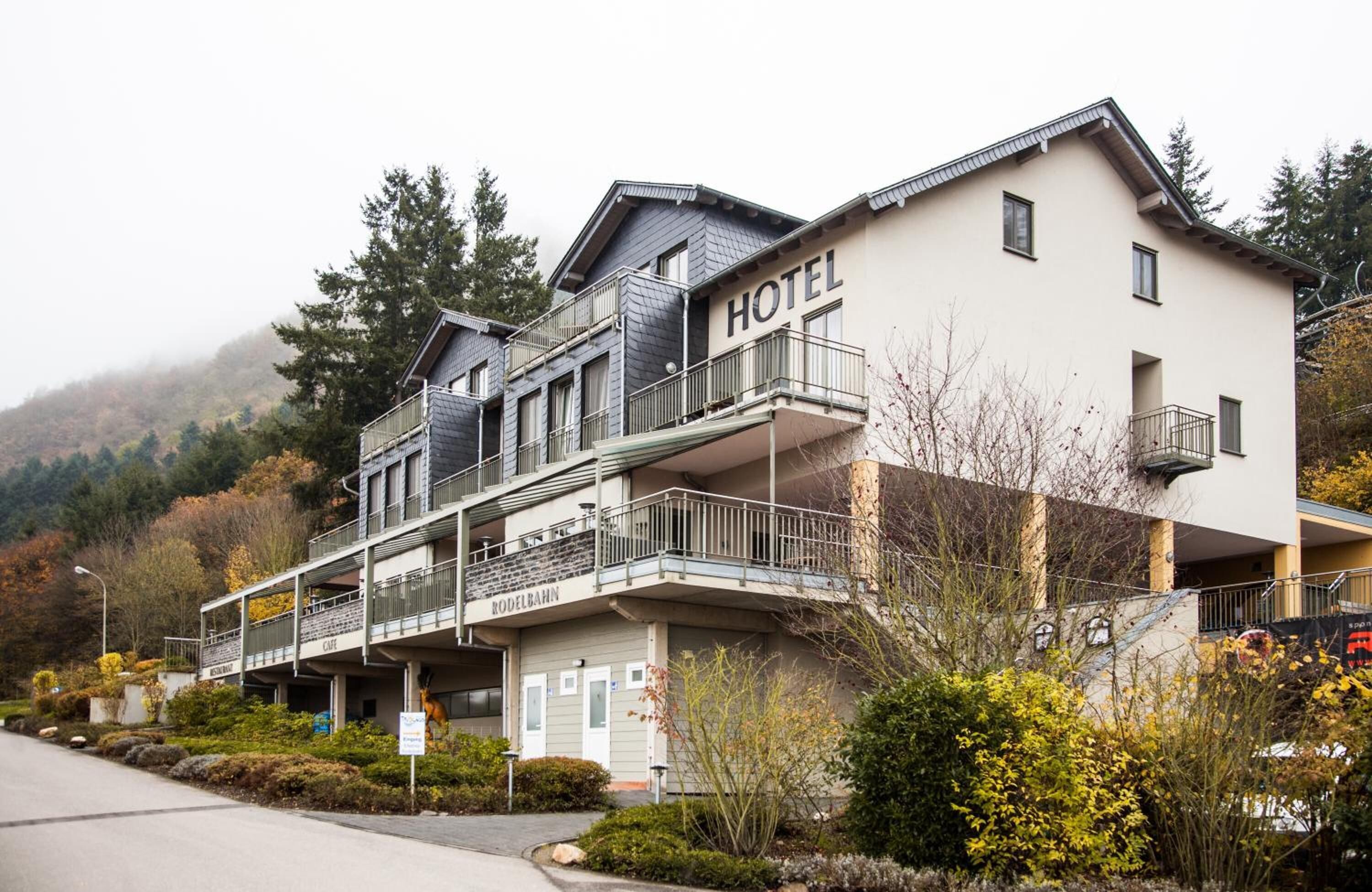 A hotel with a modern design, featuring multiple balconies and a prominent "HOTEL" sign.