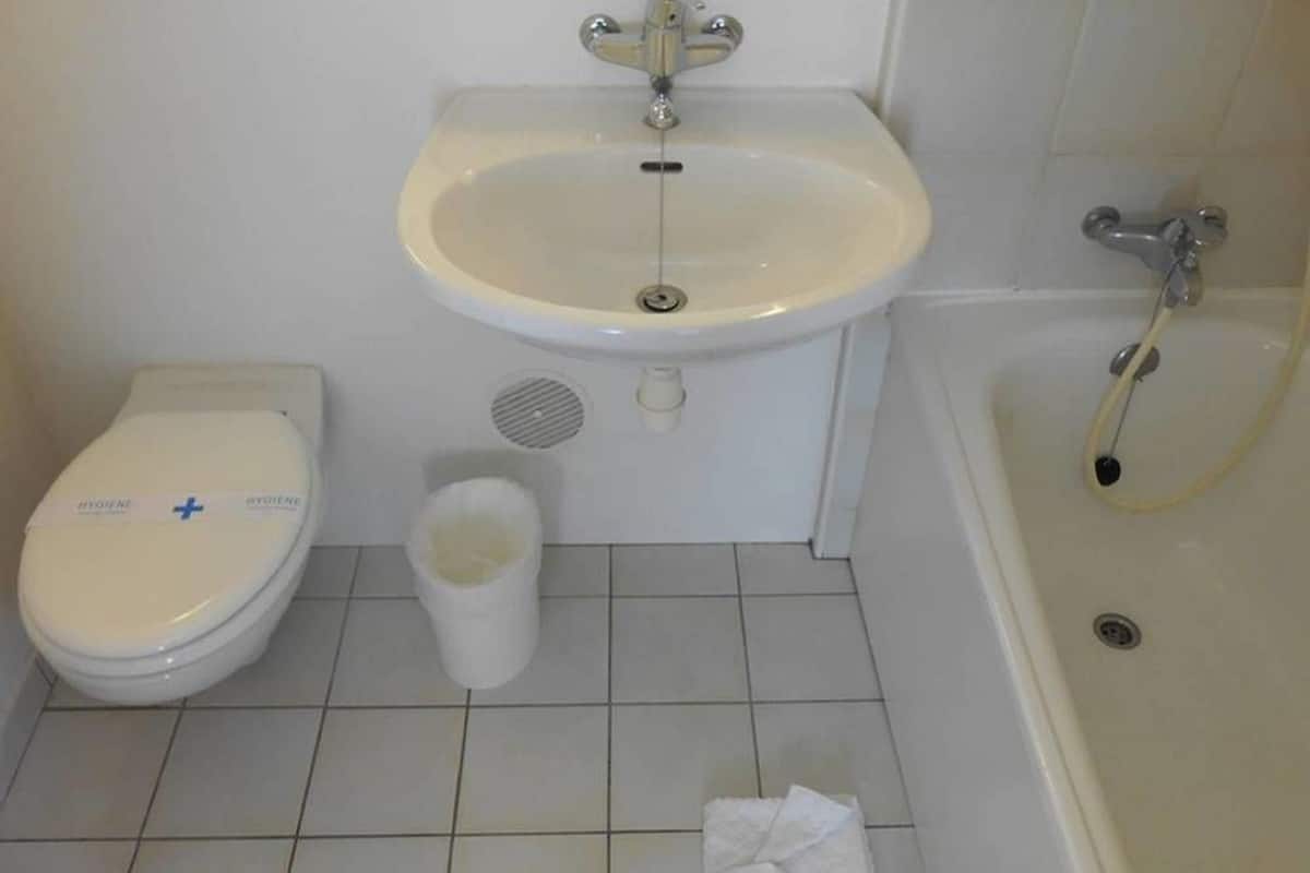 A bathroom with a toilet, bidet, and bathtub.