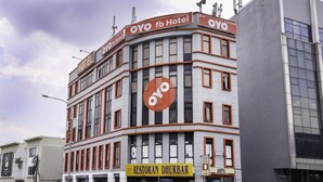 Un hotel con un llamativo logotipo de 'OYO' y señalización que indica 'OYO fb Hotel'.