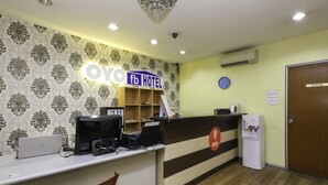 Una recepción con un cartel que dice 'fb HOTEL', un reloj y un dispensador de agua.