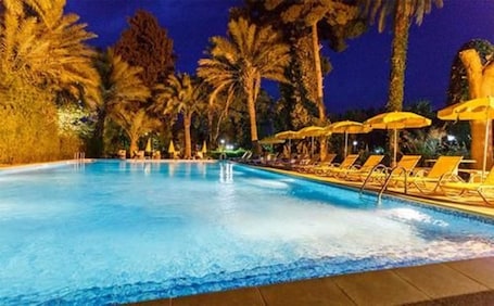 Una piscina al aire libre, sombrillas, tumbonas. Hôtel Kerdada