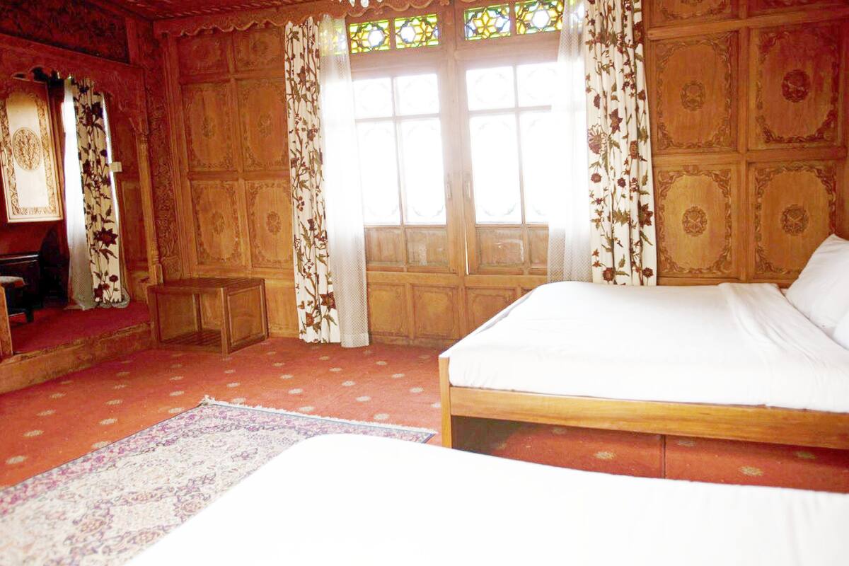A room with a bed, a small table, and a window with curtains.