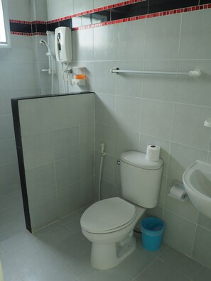 Un baño con inodoro, bidé y un pequeño cubo de basura azul.