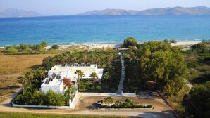 A coastal property with a central building surrounded by palm trees and a beach. - Cavo D'oro Hotel (Kos)